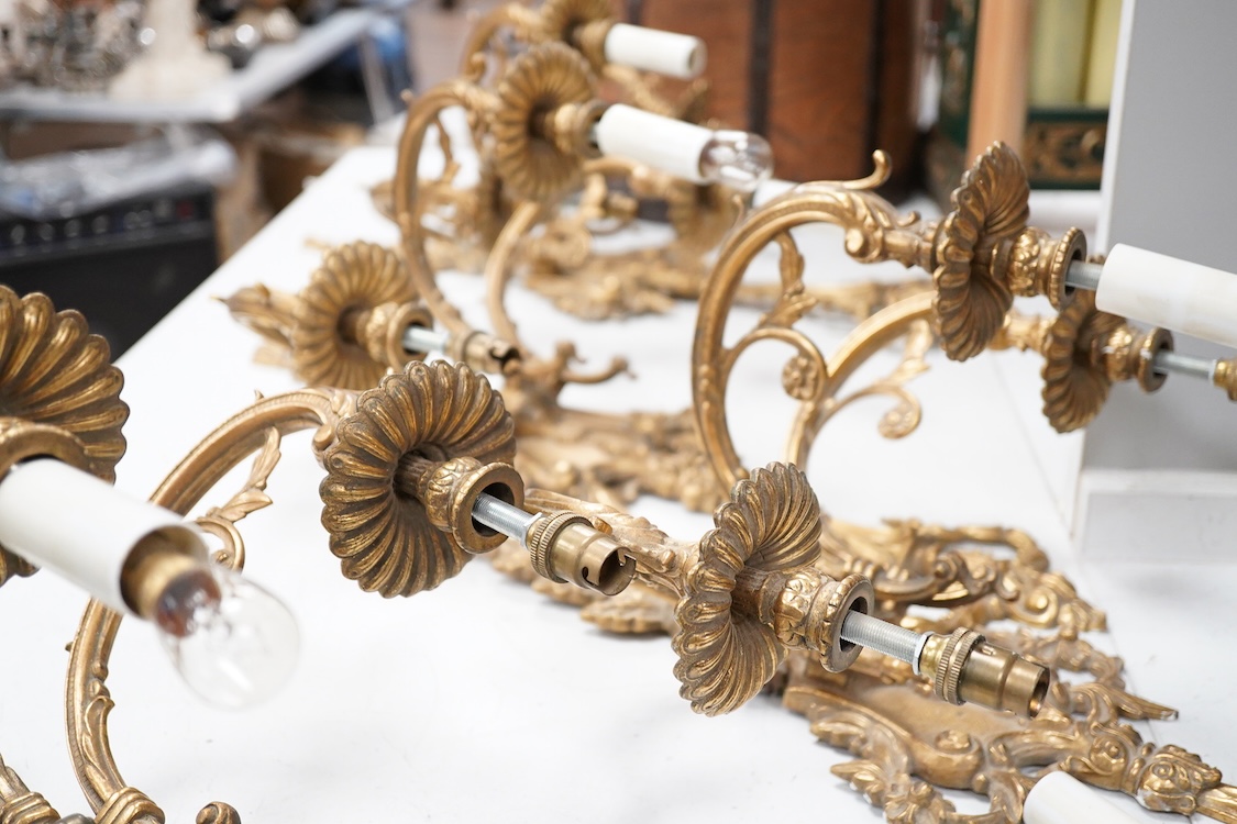 A set of four Louis XVI style three branch gilt bronze wall lights, 62.5cm high x 40cm wide